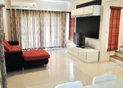 Modern living room with large windows and red sofa