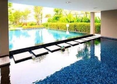 Indoor-outdoor pool area with water feature and basketball hoop