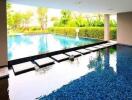 Indoor-outdoor pool area with water feature and basketball hoop