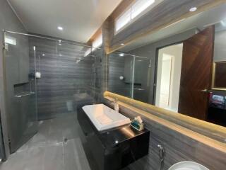 Modern bathroom with glass-enclosed shower and large mirror