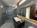 Modern bathroom with glass-enclosed shower and large mirror