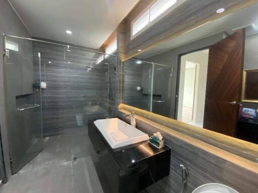 Modern bathroom with glass-enclosed shower and large mirror