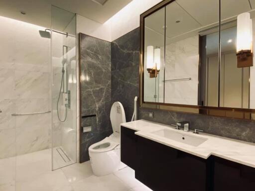 Modern bathroom with a shower, toilet, and dual-sink vanity