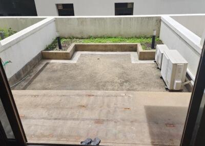 Outdoor balcony area with concrete flooring and air conditioning unit