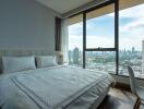 Bedroom with a large window and city view