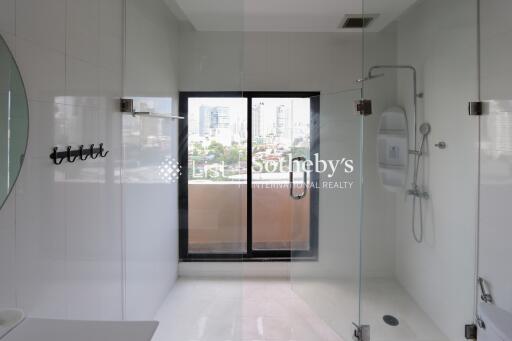 Modern bathroom with glass shower enclosure and city view