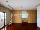 Spacious bedroom with large windows and built-in wooden wardrobes