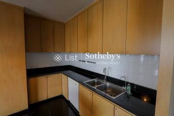 Modern kitchen with light wood cabinets and black countertops