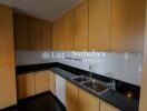 Modern kitchen with light wood cabinets and black countertops