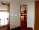 Open door view into another room with wooden flooring