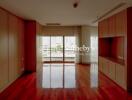 Spacious living area with large window and wooden flooring