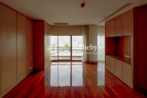 Spacious living area with large window and wooden flooring