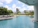 Outdoor pool area with lounge chairs and city view