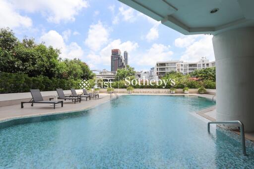 Outdoor pool area with lounge chairs and city view