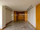 Spacious and well-lit corridor with marble flooring and wooden accents