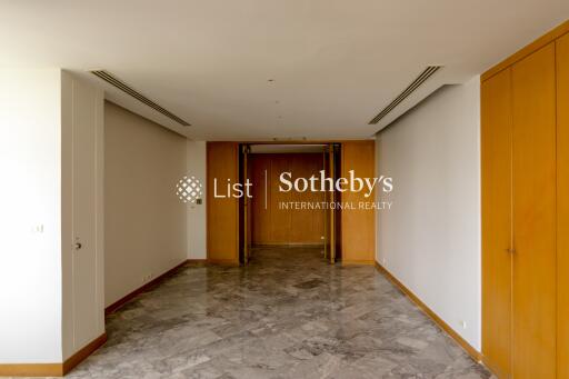 Spacious and well-lit corridor with marble flooring and wooden accents