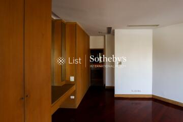 Empty room with wooden wardrobe and dark flooring