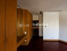 Empty room with wooden wardrobe and dark flooring