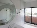 Modern bathroom with circular mirror and glass shower