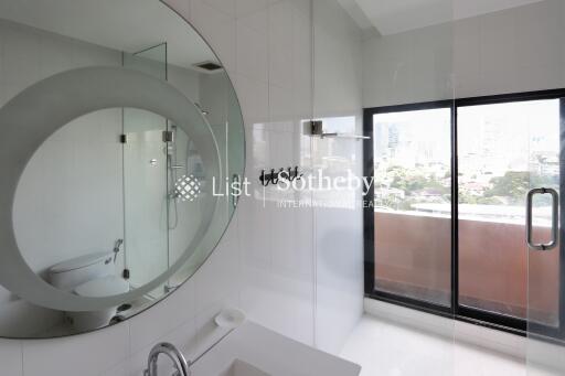 Modern bathroom with circular mirror and glass shower