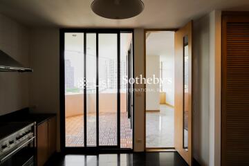 Modern kitchen with stainless steel appliances and view of adjoining room