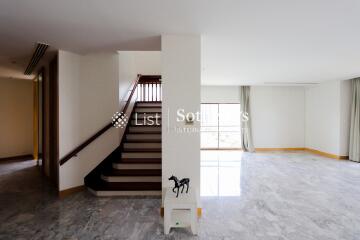 Spacious living room with staircase and large windows