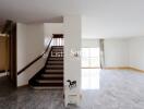 Spacious living room with staircase and large windows