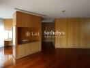 Spacious living room with wooden cabinets and hardwood flooring