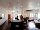 Spacious living room with modern furniture and a central wooden table