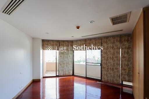 Spacious living room with large windows and wooden flooring