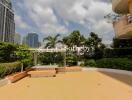 Spacious outdoor patio with a view of city skyline and lush greenery