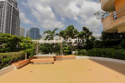 Spacious outdoor patio with a view of city skyline and lush greenery