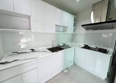 Modern white kitchen with marble countertops and built-in appliances