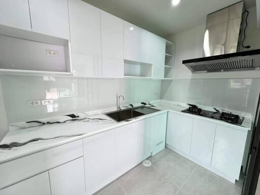 Modern white kitchen with marble countertops and built-in appliances