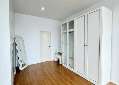 Modern bedroom with wooden flooring and large wardrobe