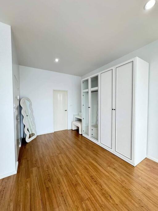 Modern bedroom with wooden flooring and large wardrobe