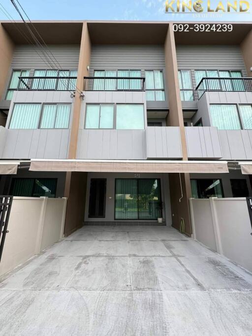 Front view of a multi-story residential building with large windows and balcony