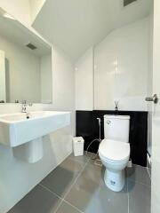 Modern bathroom with sink, toilet, and mirror