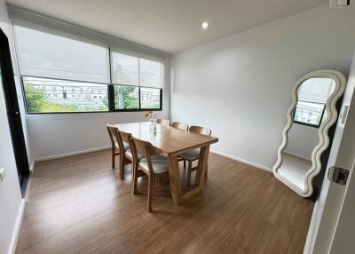 Bright dining room with table, chairs, and a large mirror