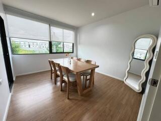 Bright dining room with table, chairs, and a large mirror