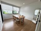 Bright dining room with table, chairs, and a large mirror