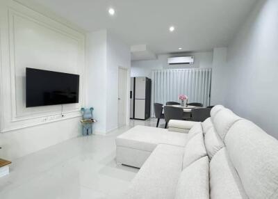 Modern living room with white sofa and wall-mounted TV