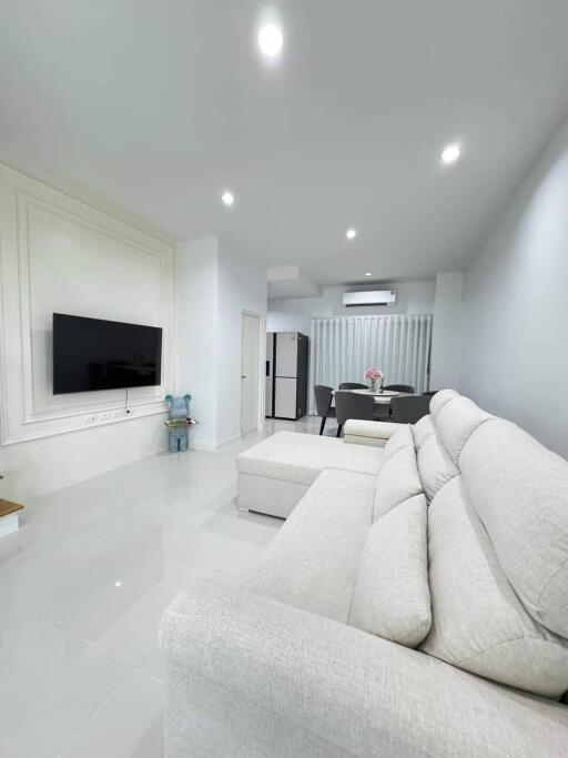 Modern living room with white sofa and wall-mounted TV