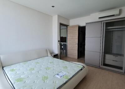 Spacious bedroom with large bed, wardrobe, and air conditioning