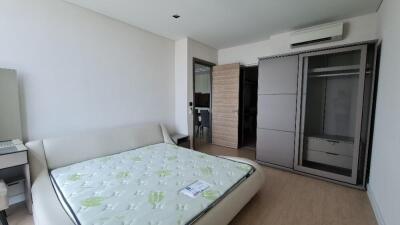 Spacious bedroom with large bed, wardrobe, and air conditioning