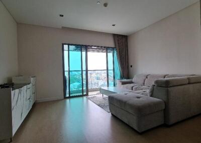 Spacious living room with large sofa and balcony view