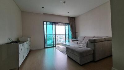 Spacious living room with large sofa and balcony view