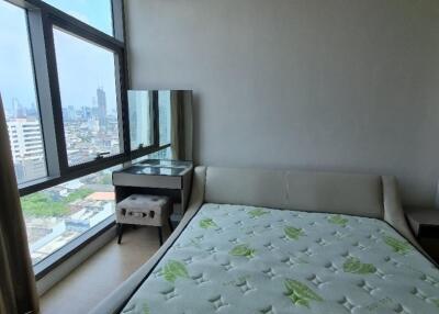 Spacious bedroom with a large window and city view