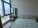 Spacious bedroom with a large window and city view