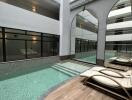 Indoor swimming pool area with lounge chairs